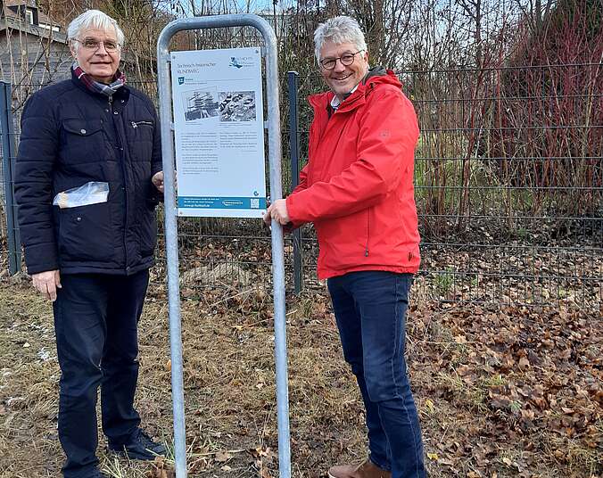 Zwei Männer neben Schild